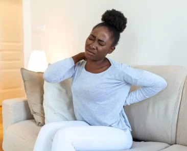 Uma mulher sofre com dores nas costas.