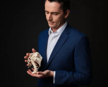 Imagem do Dr. Alexandre Jaccar segurando um biomodelo com deformidades da coluna.