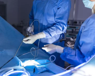 Imagem de dois médicos utilizando endoscópio com câmera, durante a realização de uma endoscopia da coluna.