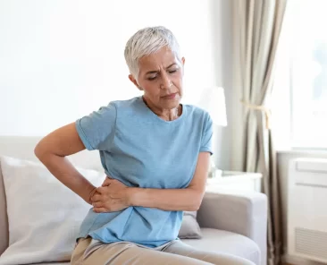 Uma mulher sofre com dor ciática.