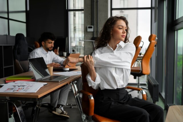 Uma jovem profissional realiza exercícios para melhorar a ergonomia no trabalho.