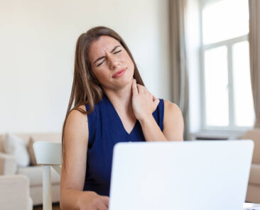 Uma mulher jovem sofre com dores no pescoço e cervical.