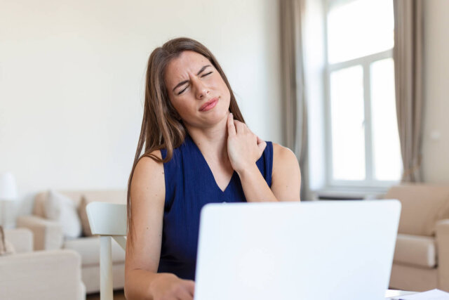 Uma mulher jovem sofre com dores no pescoço e cervical.