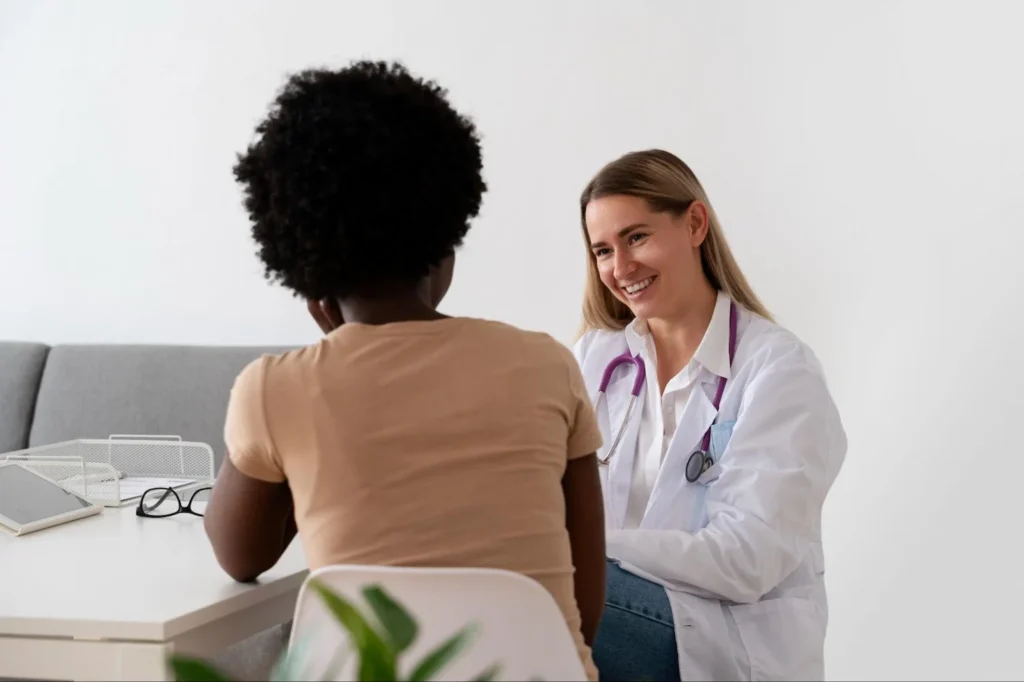 Mulher em consulta médica falando sobre sintomas na coluna.