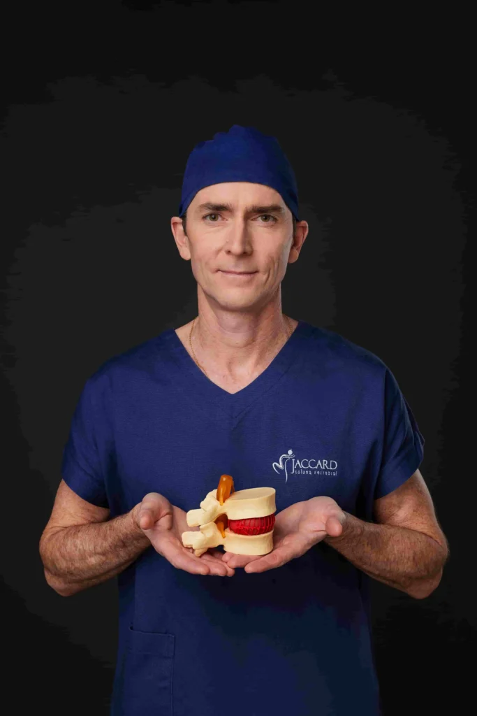 Dr. Alexandre Jaccard, ortopedista online, segurando um modelo anatômico da coluna vertebral e disco intervertebral